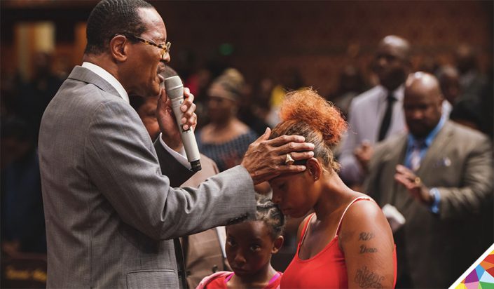 Bishop blake blesses a woman at the altar call at west angeles church